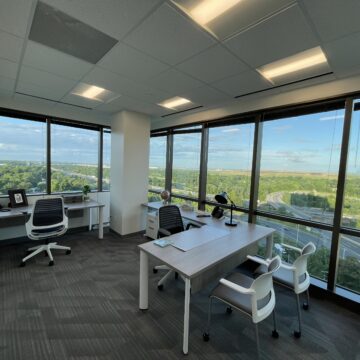 a picture of a shared office space with big windows and a